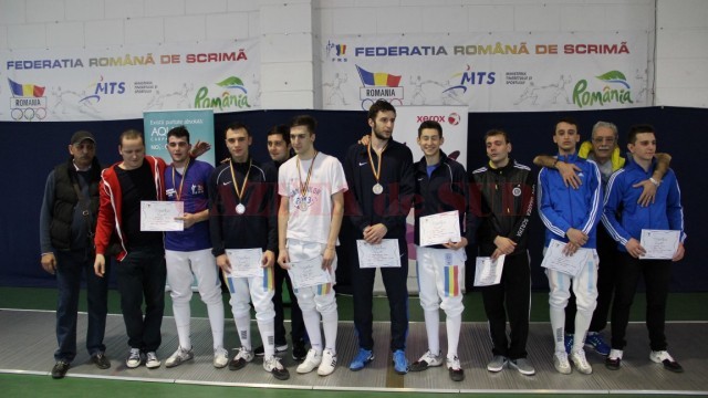 Trei dintre spadasinii craioveni au urcat pe podium la Campionatul Naţional de tineret. Tatian Bolboceanu (al treilea din stânga), de la CSM Craiova, a cucerit aurul, Mario Persu (al patrulea din stânga), de la CS Universitatea, s-a clasat pe locul doi, iar Ionuţ Trandafirescu (în centru, în trening), de la CS Universitatea, s-a clasat pe locul al treilea (foto: frscrimă)