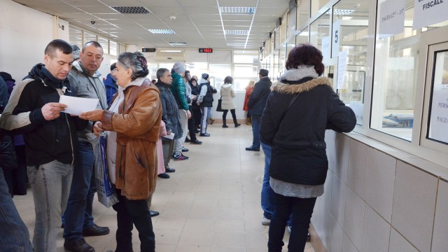 Craiovenii sunt obligați să stea la coadă pentru a-și achita taxele și impozitele locale. Sistemul de plată on-line este blocat din cauza neînțelegerilor dintre primărie și Banca Transilvania (FOTO: GdS)