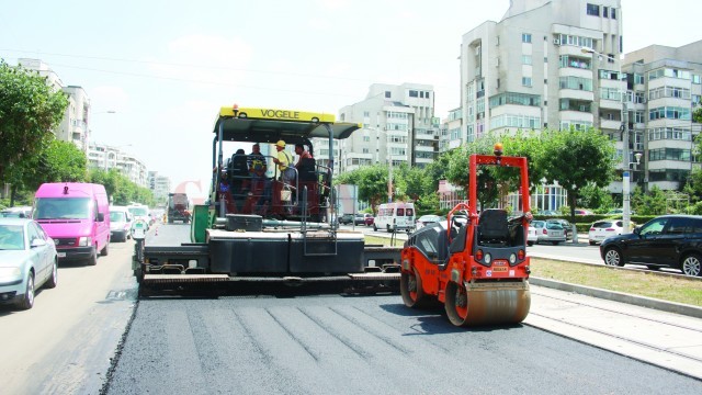 Asfaltarea străzii Calea București a început ieri, cu o zi întârziere față de data pe care o anunțaseră reprezentanții municipalității (Foto: Traian Mitrache)