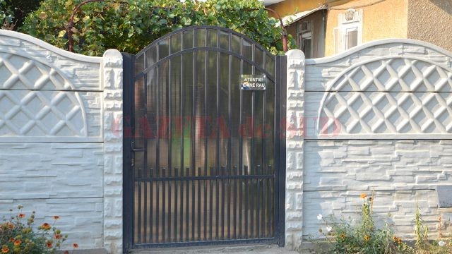 Pe poarta curţii în care a fost ucis bărbatul este montată o plăcuţă cu inscripţia: „Atenţie, câine rău!“ (Foto: Claudiu Tudor)