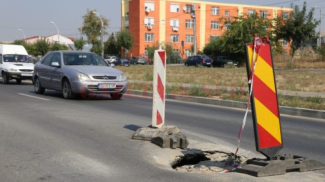 Pe strada Râului, recent recepționată, s-au lăsat mai multe guri de canal, iar șoferii sunt nevoiți să facă slalom printre balizele de avertizare (Foto: Lucian Anghel)