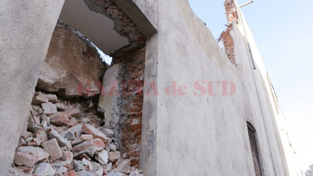 Ferestrele zidului, aflate chiar deasupra trotuarului, sunt pline cu cărămizi gata să cadă