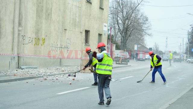 Lucrătorii făceau semne şoferilor să oprească, în timp ce excavatorul dărâma bucăţi din zidul morii (Foto: Bogdan Grosu)