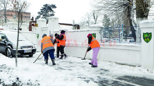 Muncitorii de la Salubritate curăță trotuarele de pe strada Caracal (Foto: Bogdan Grosu)