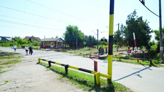 Oamenii traversează calea ferată chiar şi atunci când bariera este coborâtă (Foto: Bogdan Grosu)