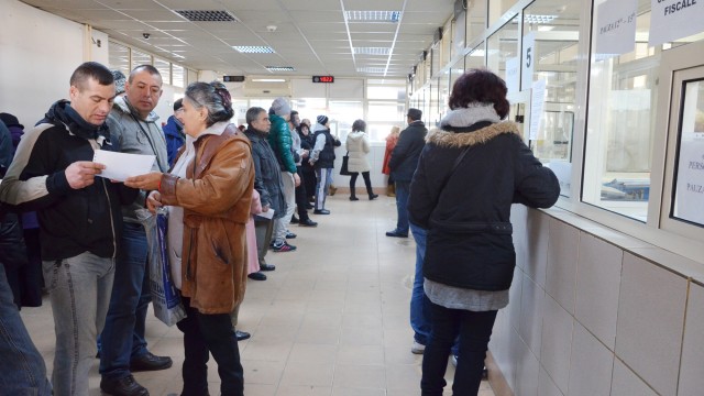 Craiovenii sunt obligați să stea la coadă pentru a-și achita taxele și impozitele locale. Sistemul de plată on-line este blocat din cauza neînțelegerilor dintre primărie și Banca Transilvania  (FOTO: GdS)