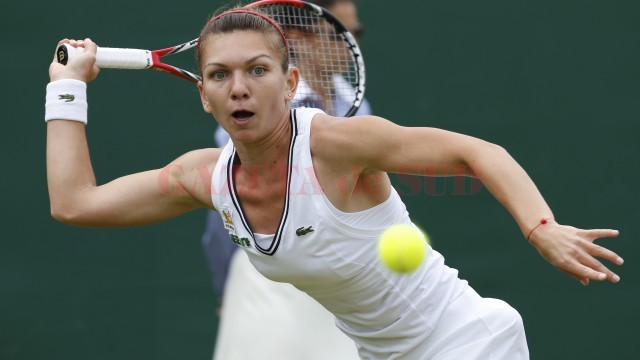 Simona Halep of Romania hits a return to Li Na of China during their women's singles tennis match at the Wimbledon Tennis Championships, in London