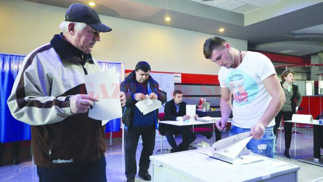 Un tânăr din Cârcea era cât pe ce să aplice ștampila pe buletinele de vot în afara cabinei de votare. El a fost observat la timp de președinta secției de votare și a fost trimis în cabina de vot să aplice ștampila, așa cum spune legea. (Foto: Bogdan Grosu)