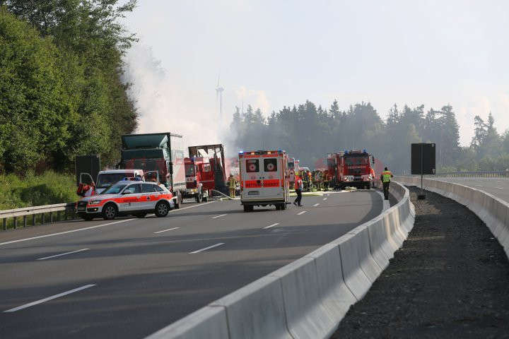 Ambulance cars and fire engines near a bus after thirty-one people were injured