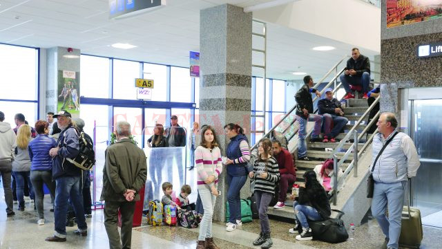 Pasagerii, însoțiți de copii, stăteau inclusiv pe scări și pe bagaje, în așteptarea decolării (Foto: Lucian Anghel)