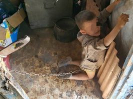 Copil de 6 ani, legat cu lanţul în grajd şi biciuit de tatăl său