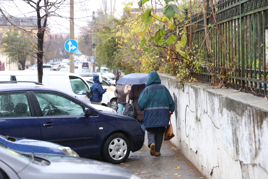 Pietonii se strecoare cu greu printre maşinile parcate pe trotuar