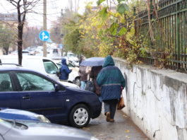 Pietonii se strecoare cu greu printre maşinile parcate pe trotuar