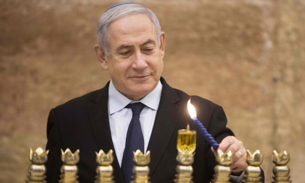 Benjamin Netanyahu aprinzând candele în ziua de Hanuka (Foto: Sebastian Scheiner/AFP/Getty)