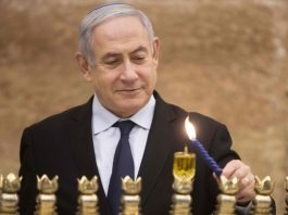 Benjamin Netanyahu aprinzând candele în ziua de Hanuka (Foto: Sebastian Scheiner/AFP/Getty)