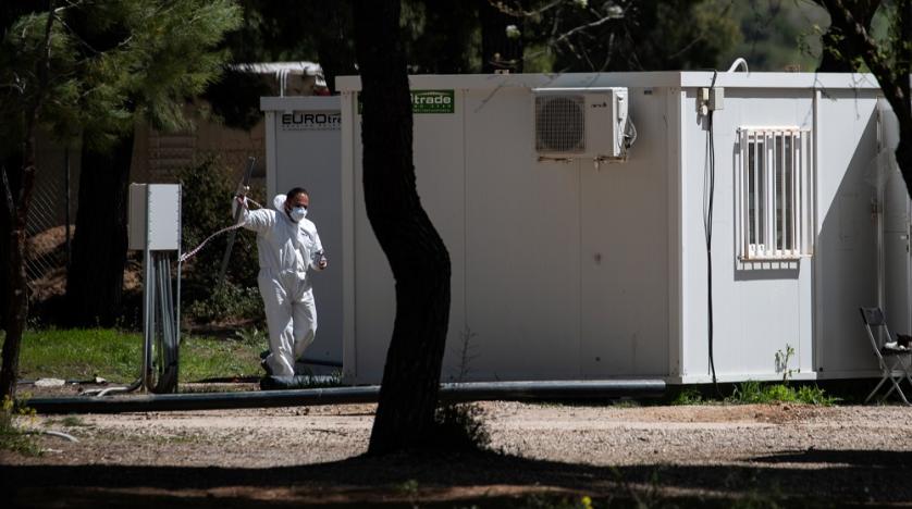 Un bărbat care poartă costum de protecție și mască își face drum în tabăra de migranți din Ritsona, după ce autoritățile au găsit 20 de cazuri de coronavirus, în Ritsona, Grecia, 2 aprilie 2020