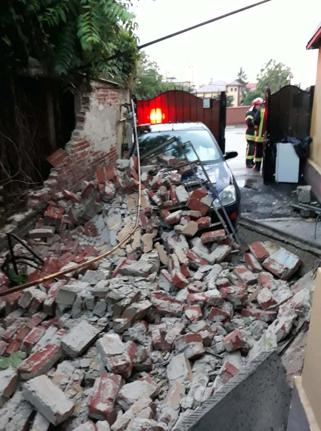 Zid vechi, prăbușit peste o țeavă de gaze și o mașină în urma ploii torențiale