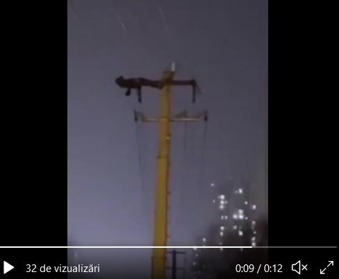 Imagini inedite: Un bărbat face abdomene pe un stâlp de electricitate