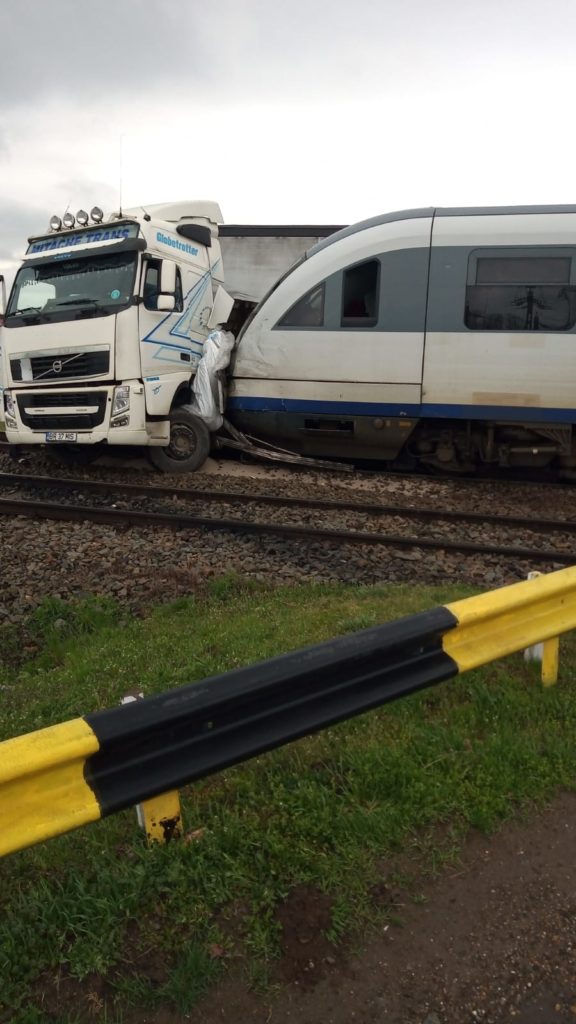 TIR, lovit de două trenuri. Șoferul a scăpat ca prin minune