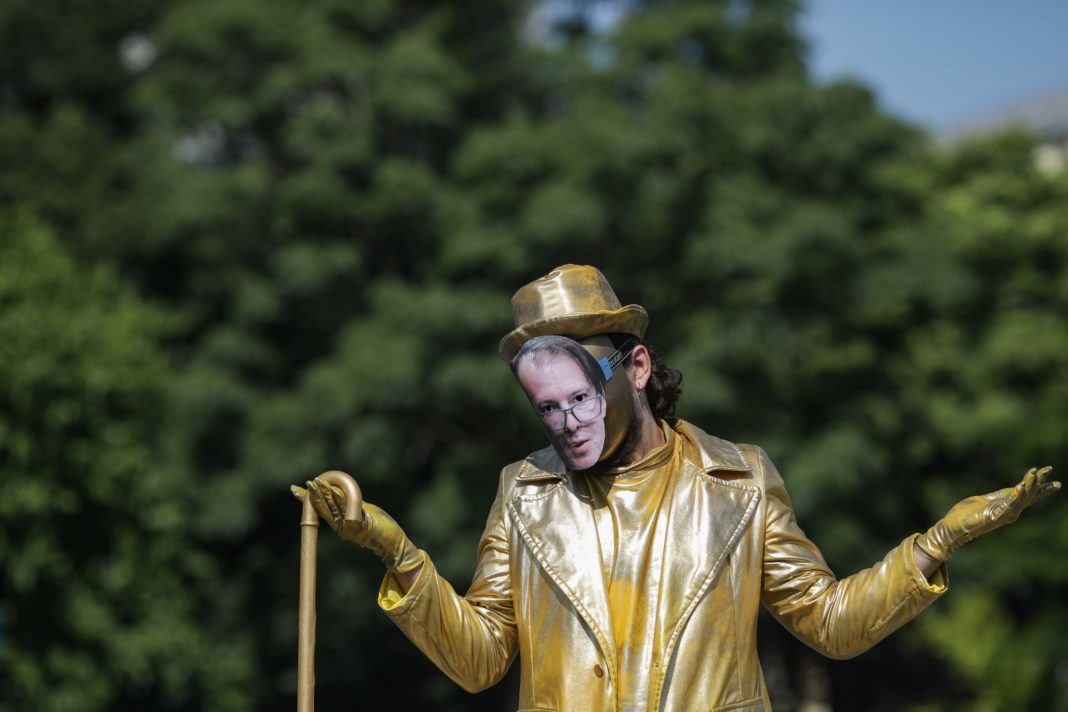 Activiştii de mediu au dezvelit în Piaţa Victoriei o statuie care îl întruchipează pe premierul Florin Cîțu ”poleit în aur” (Foto: Octav Ganea)