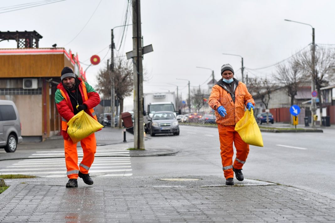 Angajaţii Salubrităţii împrăştie sare pe unul dintre trotuarele Craiovei