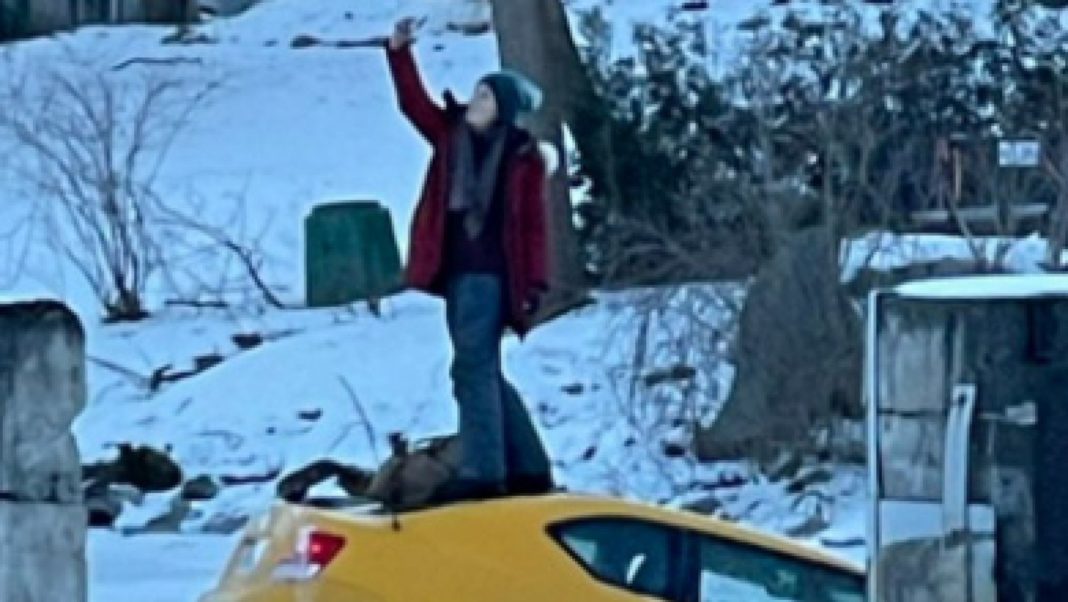 (VIDEO) După ce a căzut cu maşina într-un râu înghețat, s-a urcat pe capotă pentru un selfie