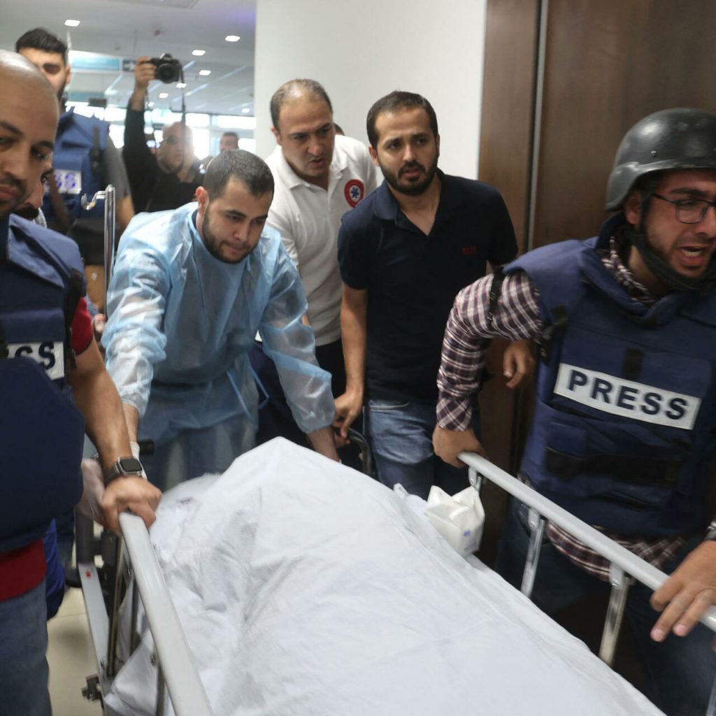 Jurnaliştii escortează cadavrul jurnalistei veterane Al Jazeera Shireen Abu Aqleh, care a fost împuşcat mortal de trupele israeliene în timp ce acoperi un raid în tabăra de refugiaţi Jenin din Cisiordania, pe 11 mai 2022, la spitalul din Jenin. (Foto: Jaafar Ashtiyeh/ AFP)