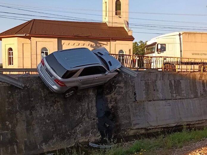 O mașină a rămas „agățată“ de un pod după un accident (foto: Mihalceak Ludovic)