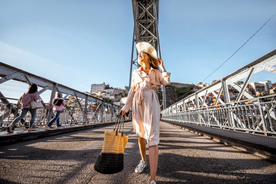 Vedere pe faimosul pod Luis cu o femeie care merge în timpul zilei însorite în orașul Porto, Portugalia