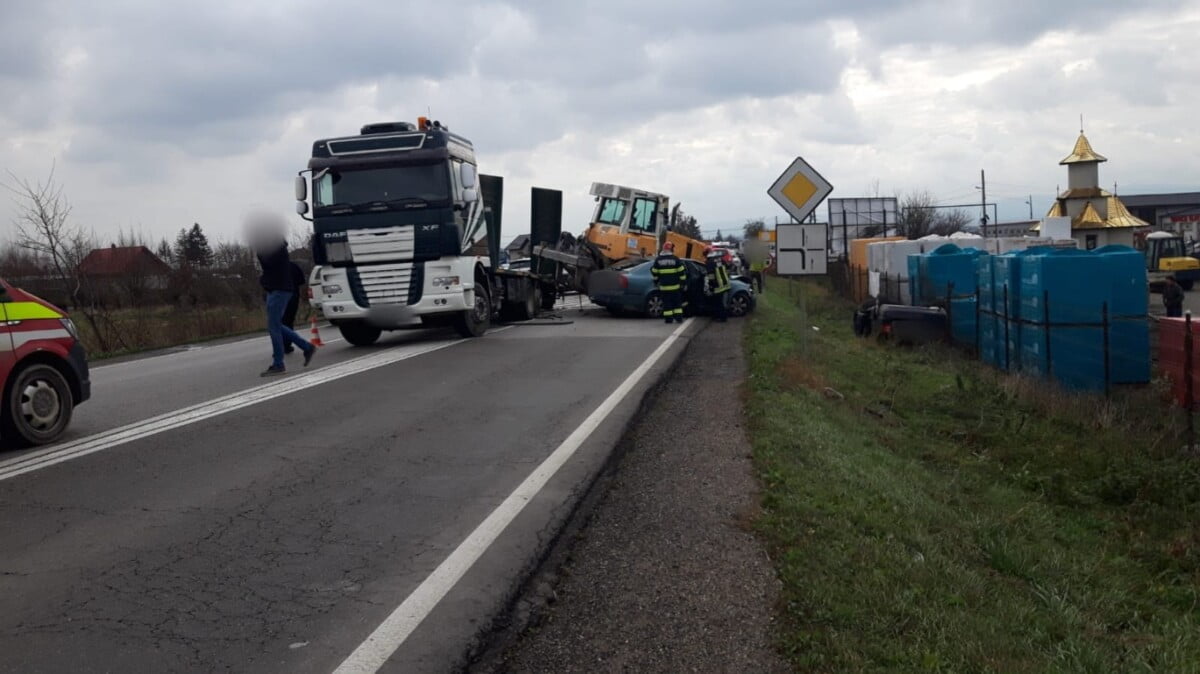 Trei răniţi după ce un utilaj a căzut de pe o platformă peste două autoturisme