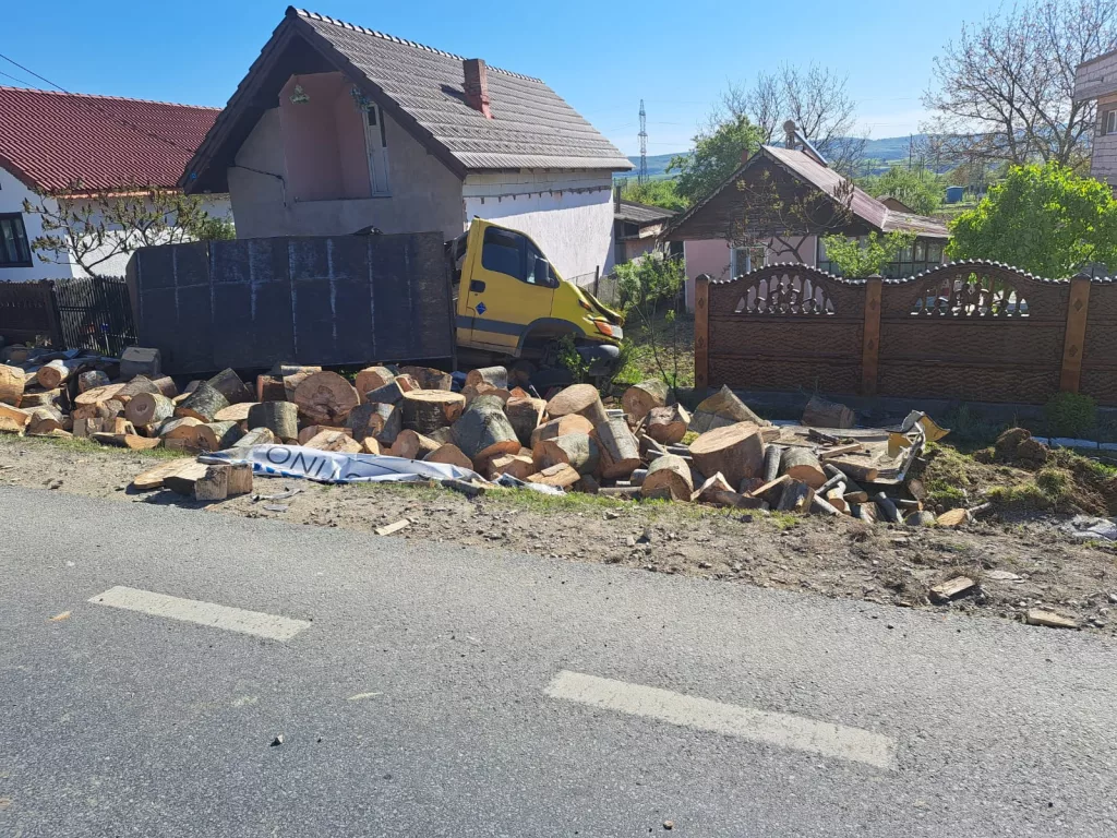 Mașină cu lemne, răsturnată în curtea unei case din Plopșoru