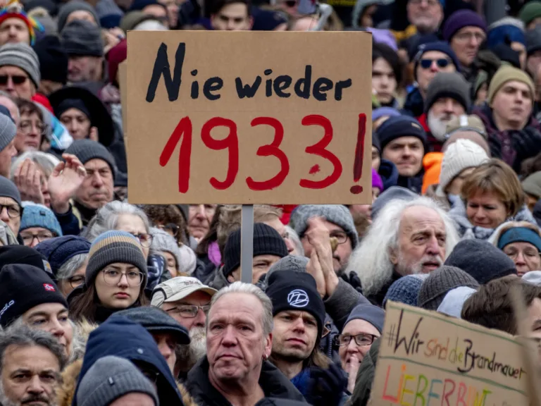 Oamenii se adună în timp ce protestează împotriva partidului AfD și a extremismului de dreapta la Frankfurt/Main, Germania, sâmbătă, 20 ianuarie 2024. Semnul scrie „Niciodată 1933”. (AP Photo/Michael Probst)
