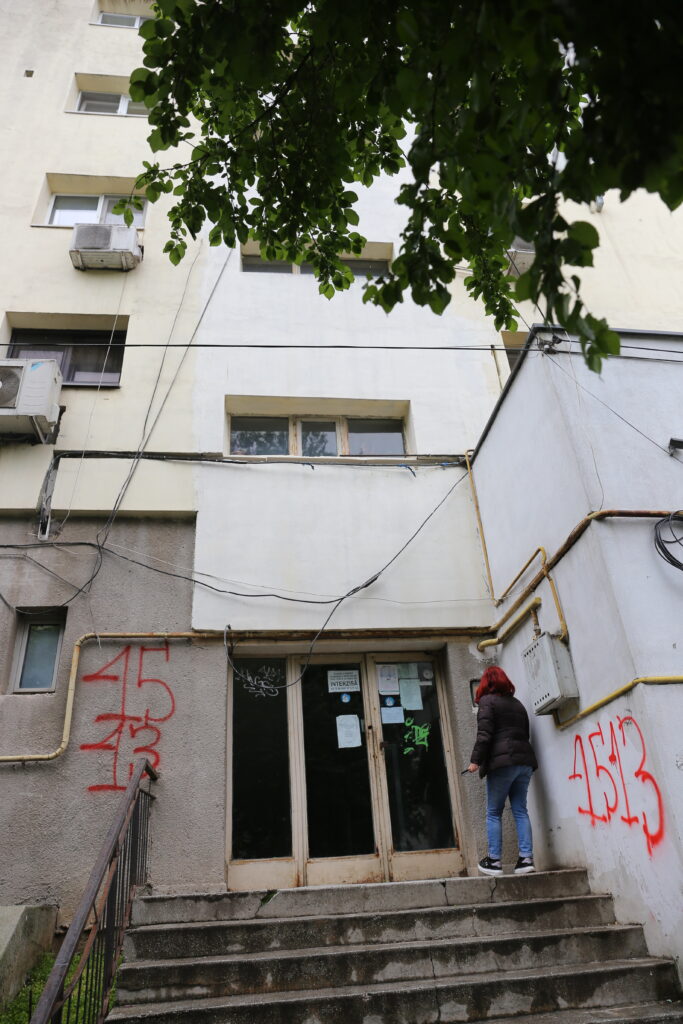O locatară dintr-un bloc din buricul oraşului îşi face nevoile în găleată.Femeia aruncă mizeriile în spaţiul verde din faţa blocului