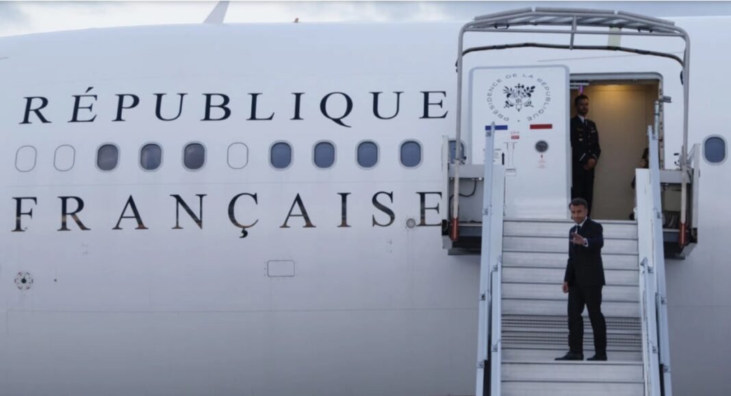 Președintele Franței, Emmanuel Macron, salută cu mâna în timp ce se urcă în avionul său prezidențial pentru a călători în arhipelagul Pacific al Noua Caledonie, în încercarea de a rezolva o criză politică, pe aeroportul din Orly