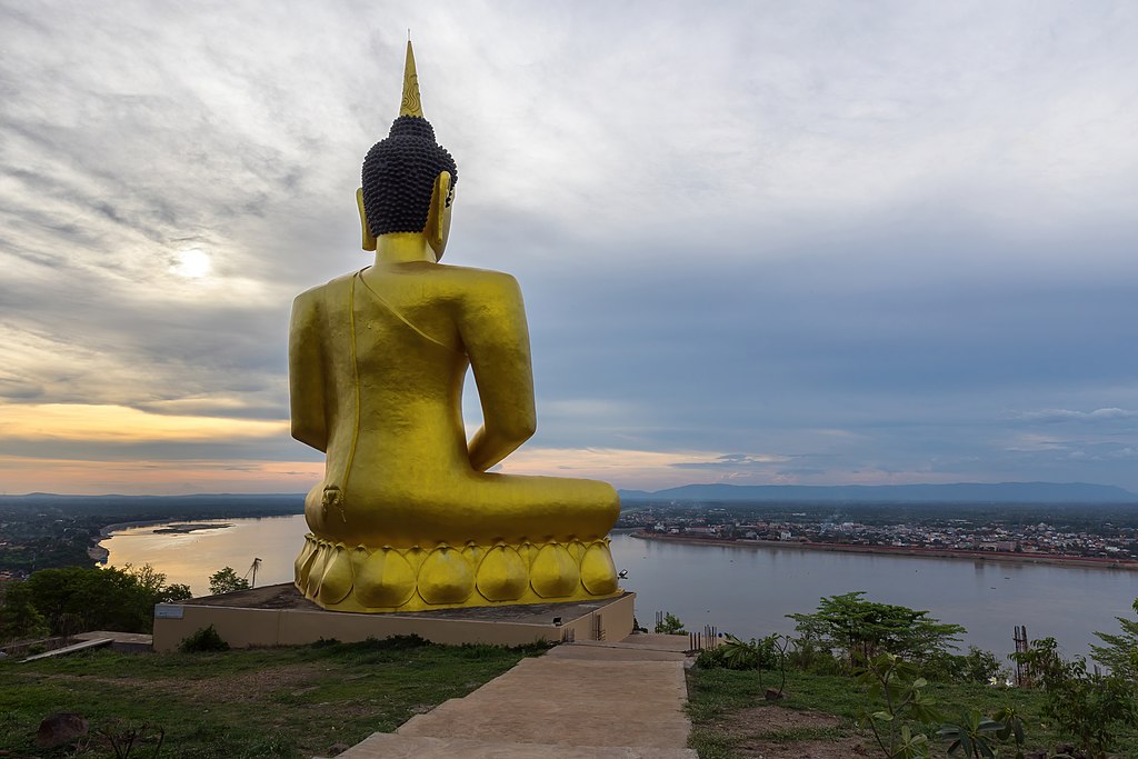 1024px-Golden_Buddha_seen_from_behind_at_sunset_at_Wat_Phou_Salao_temple_in_Pakse_Laos Statuia lui Buddha în Wat Phou