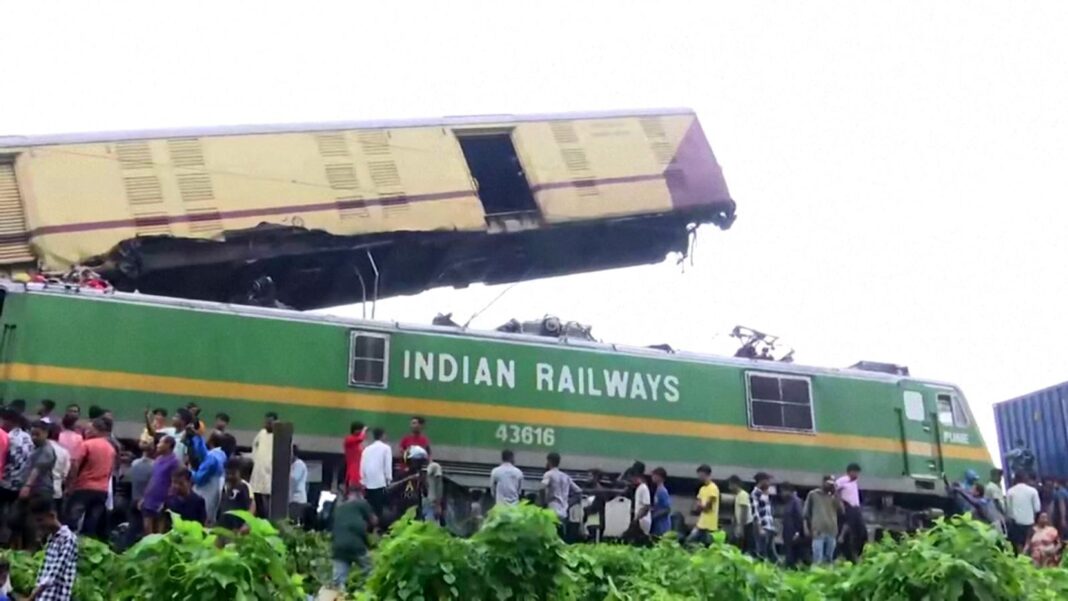 Oamenii se adună în jurul epavei unui tren după o coliziune în Bengalul de Vest, India, pe 17 iunie 2024