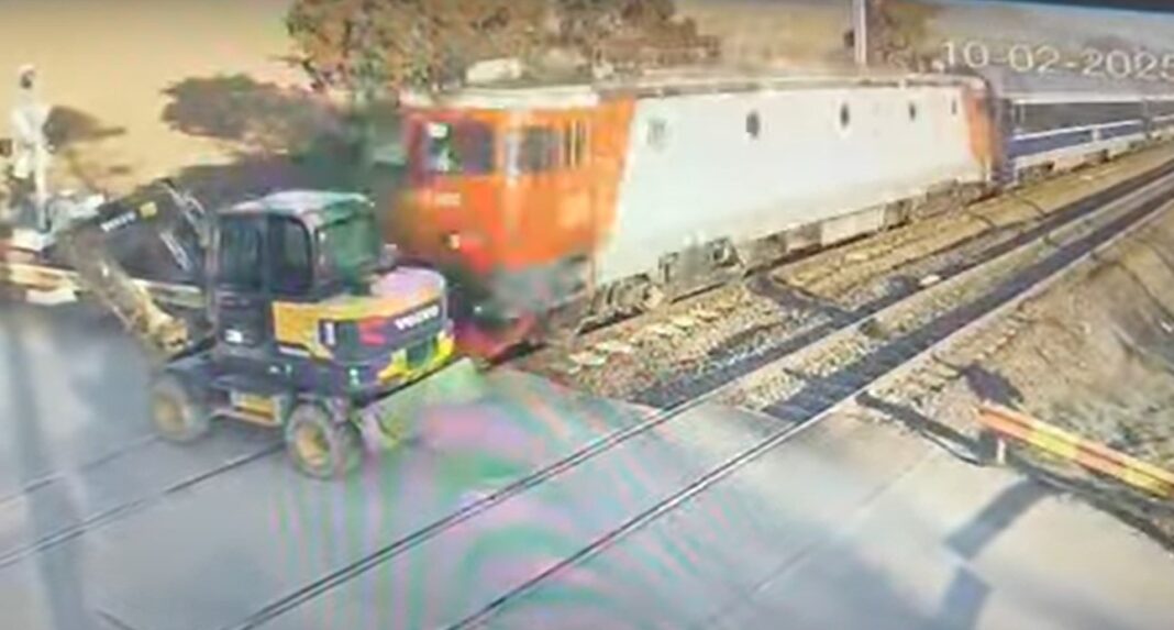 Buldoexcavator lovit de tren la o trecere la nivel cu calea ferată