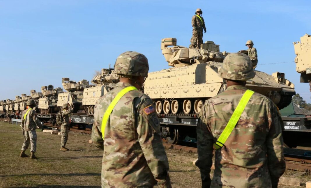 Membrii Diviziei 1 a Armatei SUA Regimentul 9 Batalionul 1 descarcă echipamente grele de luptă, inclusiv tancuri Abrams și vehicule de luptă Bradley, la gara de lângă baza militară Pabrade din Lituania