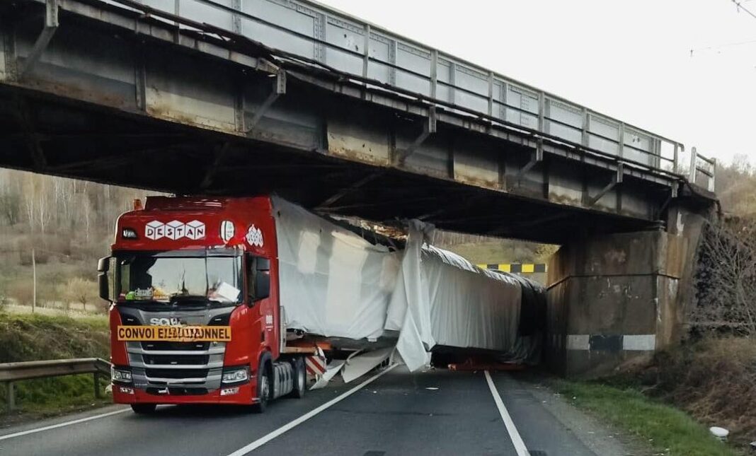 Un TIR care transporta un tramvai a rămas blocat sub un pod CFR