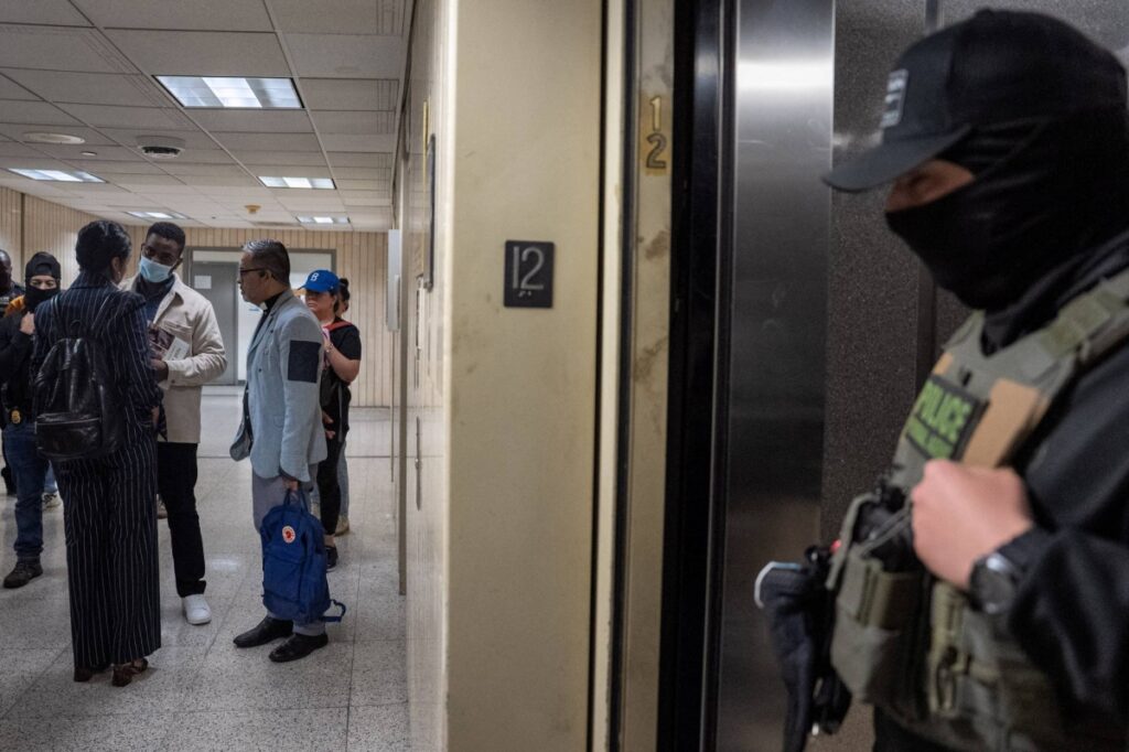 Un migrant este reținut de ofițeri federali la un tribunal de imigrare american din Manhattan, New York City