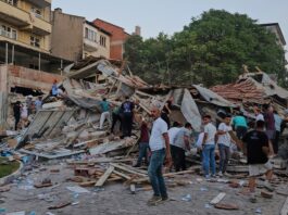 Oamenii îndepărtează rămășițele unei clădiri prăbușite în urma unui cutremur în Sindirgi, nord-vestul Turciei, duminică, 10 august 2025. (Bahadir Demirceviren/IHA via AP)