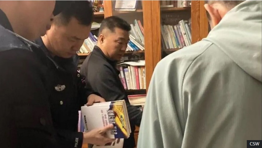 Ofițerii de poliție care îl arestau pe pastorul Sun Cong de la Biserica Sion (centru) au fost văzuți verificându-i cărțile
