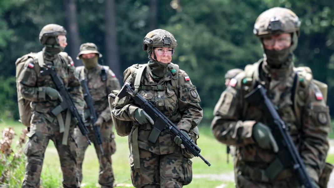 Candidații care se alătură Apărării Teritoriale a Poloniei mărșăluiesc într-o formațiune defensivă după ce au terminat 16 zile de antrenament în „Bucla Tactică” la Centrul de Antrenament al Garnizoanei Pasternik