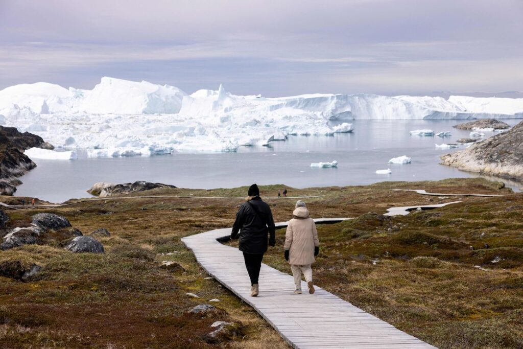 Vizitatori se plimbă de-a lungul promenadei de la Centrul Icefjord (Kangiata Illorsua) din Ilulissat pe 29 iunie 2022 (Odd Andersen/AFP/Getty Images)