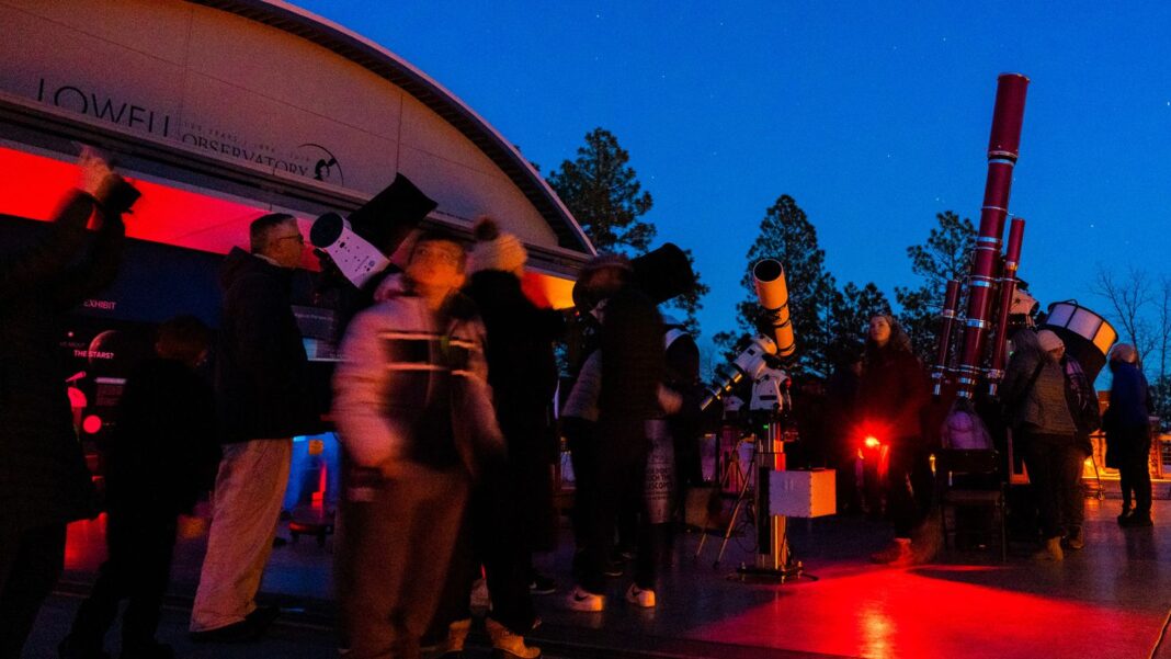 Oaspeții care vizitează Observatorul Lowell din Flagstaff, Arizona, în timpul Festivalului I Heart Pluto, privesc obiectele cerești de la Observatorul Giovale Open Deck