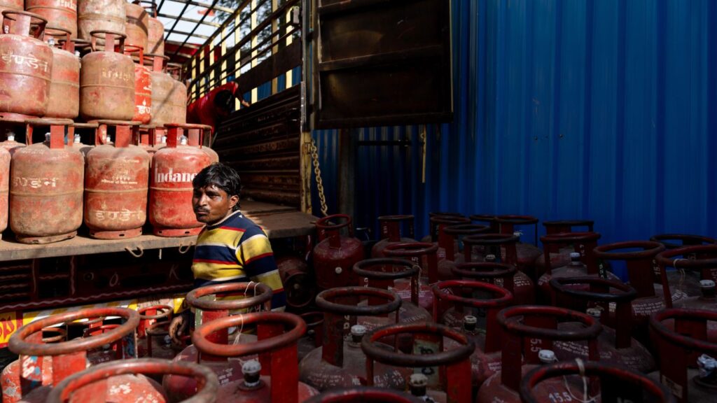 Un muncitor încarcă canistre de gaz petrolier lichefiat (GPL) epuizate într-un camion la un depozit din New Delhi, India, luni, 16 martie 2026