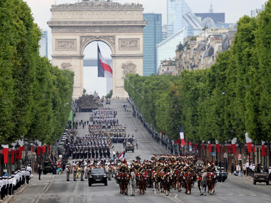 Președintele Franței și șeful Statului Major General al Apărării trec în revistă trupele în timpul paradei militare anuale de Ziua Bastiliei, pe bulevardul Champs-Élysées din Paris, pe 14 iulie 2025